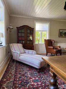 a living room with a couch and chairs and a table at Manor House - Torsberg Farm in Färgelanda