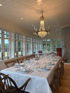 a large room with a long table with chairs and a chandelier at Manor House - Torsberg Farm in Färgelanda