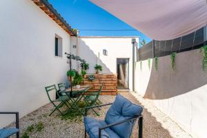 a patio with a table and chairs in a backyard at Une parenthèse en luberon, jacuzzi in Les Taillades