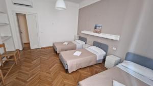 a room with two beds and a table and a chair at Lilly Home in Milan