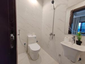 a white bathroom with a toilet and a sink at استوديو السعودية - التحلية 411 Saudi Studio -Tahlia in Jeddah