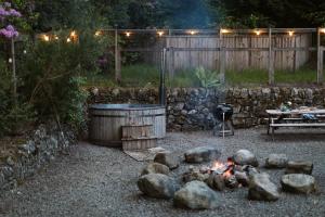 a fire pit and a tub in a yard at The Coach House in Castle Douglas