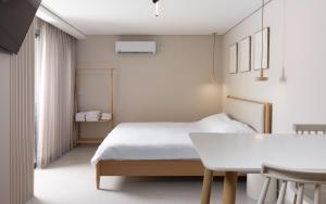 a white bedroom with a bed and a table at נופש ספיר אילת romantic in Eilat +3 photos