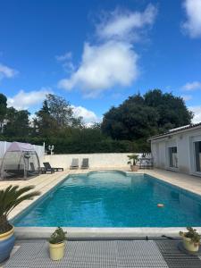 a swimming pool with blue water in a yard at LES CLÉMATITES in Donzère