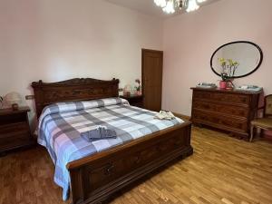 a bedroom with a bed and two dressers and a mirror at La locanda del Grottino in Torgiano