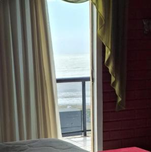 uma porta de quarto com vista para o oceano em Quarto frente mar com sacada! em Barra Velha