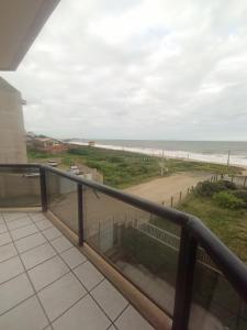 uma varanda com vista para a praia em Quarto frente mar com sacada! em Barra Velha