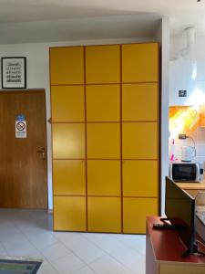 a yellow cabinet in a room with a refrigerator at La mansarda di Orni in Ivrea