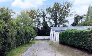 een onverharde weg voor een wit gebouw bij Studio Grimm - Tiny House in Le Cellier