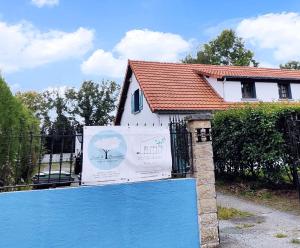 een huis met een bord voor een hek bij Studio Grimm - Tiny House in Le Cellier +1 foto