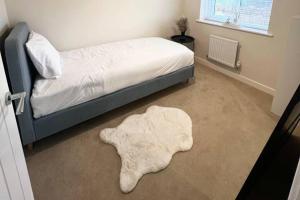 a bedroom with a bed with a rug on the floor at 3-Bed House Sleeps 5 Free Parking in Bradford