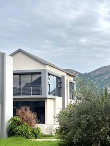 a white house with mountains in the background at Sucassa 54 - Luxury 2 Bedroom - Dam & Mountain View in Hartbeespoort