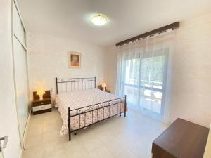 a bedroom with a bed and a large window at Appartamenti del Mare in Marina di Bibbona