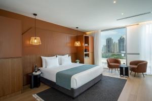 Una habitación de hotel con una cama y una ventana grande. en Prima Link Hotel, en Petaj Tikva