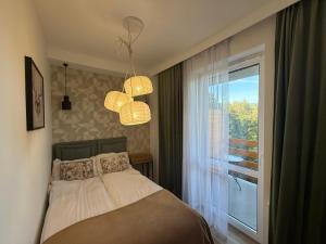 Schlafzimmer mit einem Bett, einem Fenster und Lichtern in der Unterkunft Przytulny Zakątek Karkonoszy in Karpacz