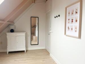 a white room with a mirror and a dresser at Cozy apartment in Enschede