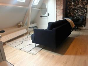 a living room with a black couch and a rug at Cozy apartment in Enschede +5 photos