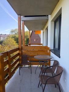 einen Balkon mit einem Tisch, Stühlen und einer Bank in der Unterkunft Przytulny Zakątek Karkonoszy in Karpacz
