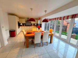 a kitchen and dining room with a wooden table and chairs at Cozy Stays Taunton in Norton Fitzwarren +22 photos