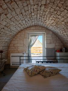une chambre avec un grand lit avec une fenêtre dans l'établissement LocoMura, à Locorotondo