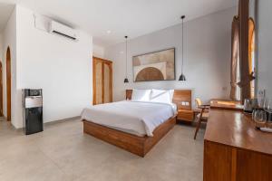 a bedroom with a bed and a desk and a kitchen at Casa del Canggu 1 - 1 bedroom villa in Pererenan