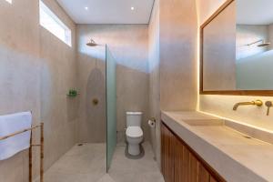 a bathroom with a toilet and a sink and a mirror at Casa del Canggu 1 - 1 bedroom villa in Pererenan