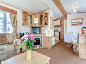 Una sala de estar con un jarrón de flores sobre una mesa. en Sunny Firth, en Edderton