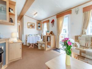 Una sala de estar con una mesa con un jarrón de flores. en Sunny Firth, en Edderton