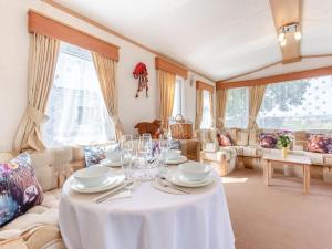 una sala de estar con una mesa con platos y copas de vino en Sunny Firth, en Edderton