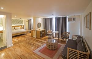 a living room with a couch and a bed in a room at Sugarland Hotel in Bacolod