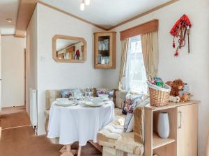 una sala de estar con una mesa y un sofá en Sunny Firth, en Edderton