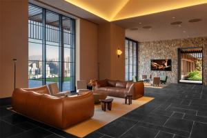 a lobby with leather furniture and a large window at Ascott Fengyishan Shenzhen in Shenzhen