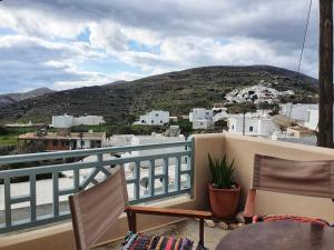 a balcony with chairs and a view of a city at Kastro Studio in Sikinos +13 photos