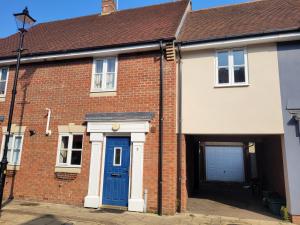 une maison en briques avec une porte bleue dans l'établissement Hythe House - Stylish Stay for Families & Groups by Catchpole Stays, à Colchester