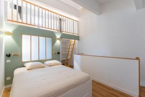 ein kleines Schlafzimmer mit einem Bett und einer Leiter in der Unterkunft Duplex Labet in La Ciotat