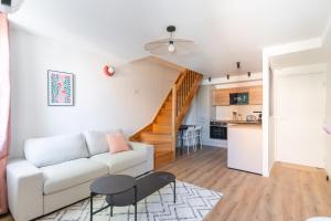 ein Wohnzimmer mit einer weißen Couch und einer Küche in der Unterkunft Duplex Labet in La Ciotat
