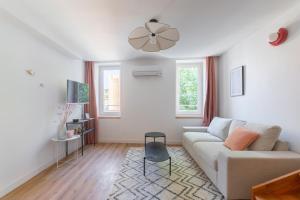 ein weißes Wohnzimmer mit einer Couch und einem Tisch in der Unterkunft Duplex Labet in La Ciotat