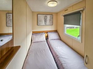 Kinmel BayにあるShaneの窓のある小さな部屋にベッドが2つある
