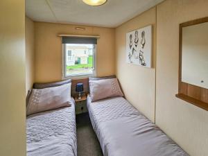 Kinmel BayにあるShaneの窓のある小さな部屋にベッドが2つある