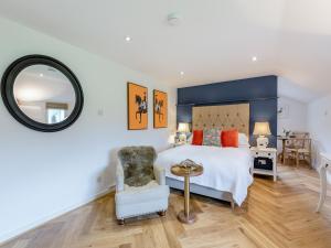 a bedroom with a bed and a chair and a mirror at The Studio in Wittersham