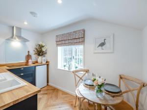 a kitchen with a table and a kitchen with a sink at The Studio in Wittersham