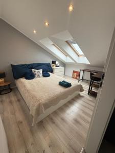 a bedroom with a bed with blue pillows on it at Apartament EcoPure pod Lasem Tychy in Tychy