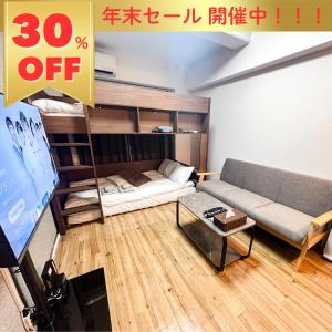 ein Wohnzimmer mit einer Couch und einem Etagenbett in der Unterkunft サンシティ大濠公園 in Susakiuramachi