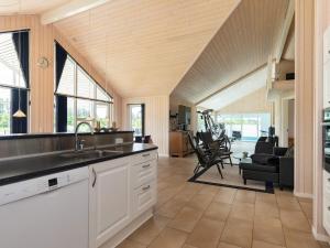 a kitchen with a sink and a living room at 5 star holiday home in Højslev in Højslev