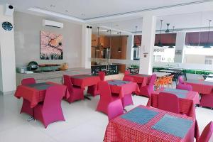 a dining room with red tables and pink chairs at Kanasha Islami in Medan