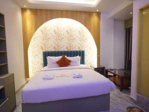 a bedroom with a large white bed in a room at Hotel The Light Park in Chittagong +29 photos
