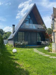 a house with a gambrel roof and a grass yard at 7Sense Nature Resort in Sapanca