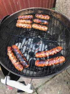 a group of sausages cooking on a grill at SOBO Studio in Bournemouth