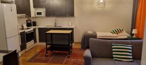 a kitchen with a couch and a table in a room at Wanha Neuvola Apartment in Pieksämäki