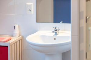 a bathroom with a white sink and a mirror at Chambres vue mer 300m plage in Plogoff +31 photos